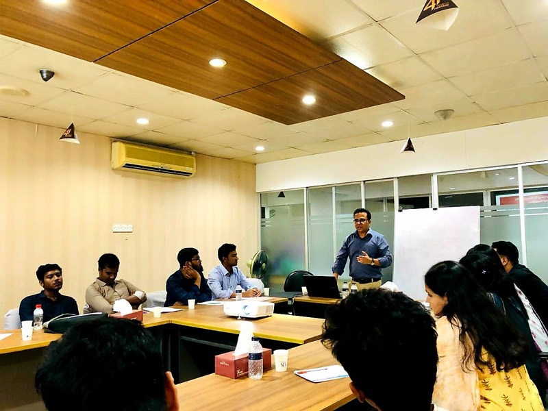 Facilitator leading a training session around a conference table